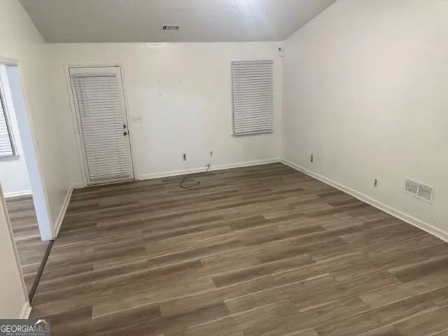 a view of a room with wooden floor and white walls