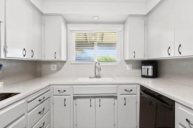 a view of an empty room with a fireplace and a window