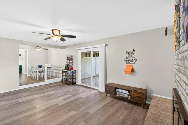 a view of a livingroom with a furniture chandelier fan and a hardwood floor