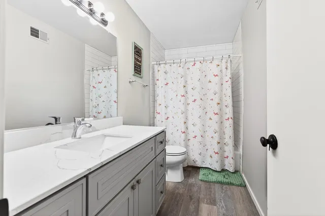 a bathroom with a granite countertop sink toilet and shower