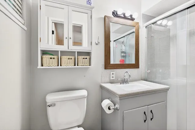 a bathroom with a shower sink vanity and mirror