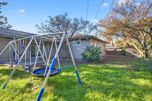 a view of a house with a yard patio and a slide