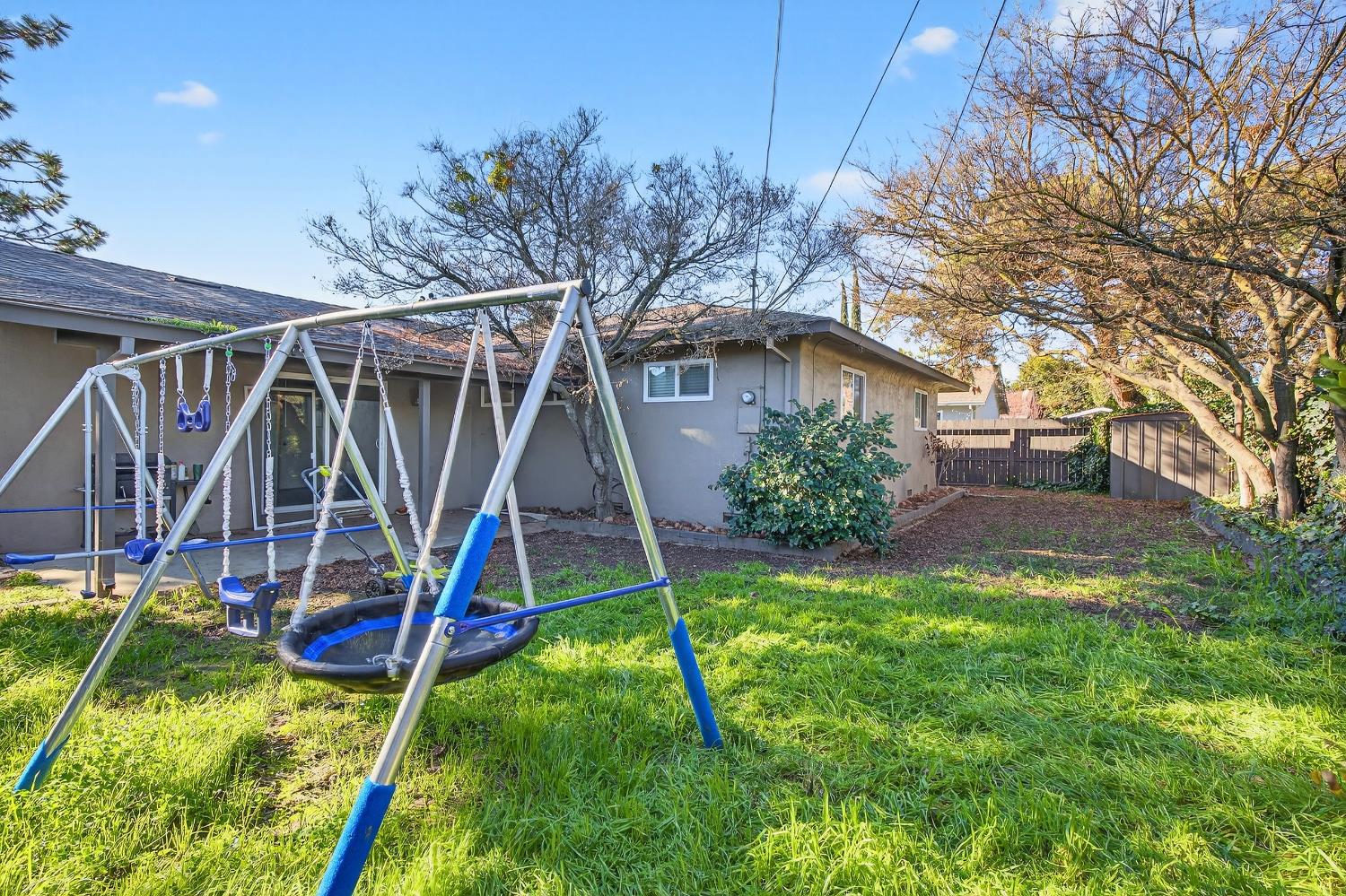 2337 Corbin Lane Lodi, CA 95242 - Photo 28 of 34 a view of a backyard with a slide and a wooden fence