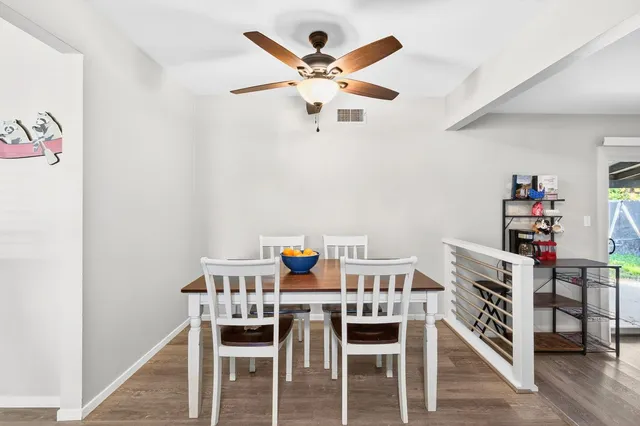 a kitchen with stainless steel appliances a white table chairs and a refrigerator