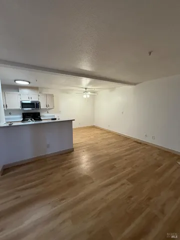 a view of a kitchen with wooden floor and electronic appliances
