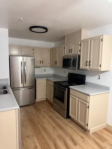 a kitchen with stainless steel appliances a refrigerator sink and cabinets