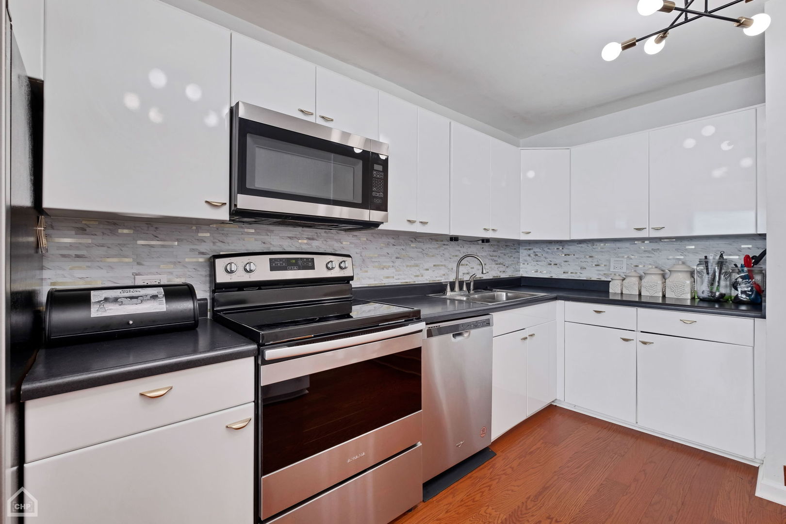 5733 North Sheridan Road, Unit 25C Chicago, IL 60660 - Photo 12 of 39 a kitchen with stainless steel appliances white cabinets and a stove top oven