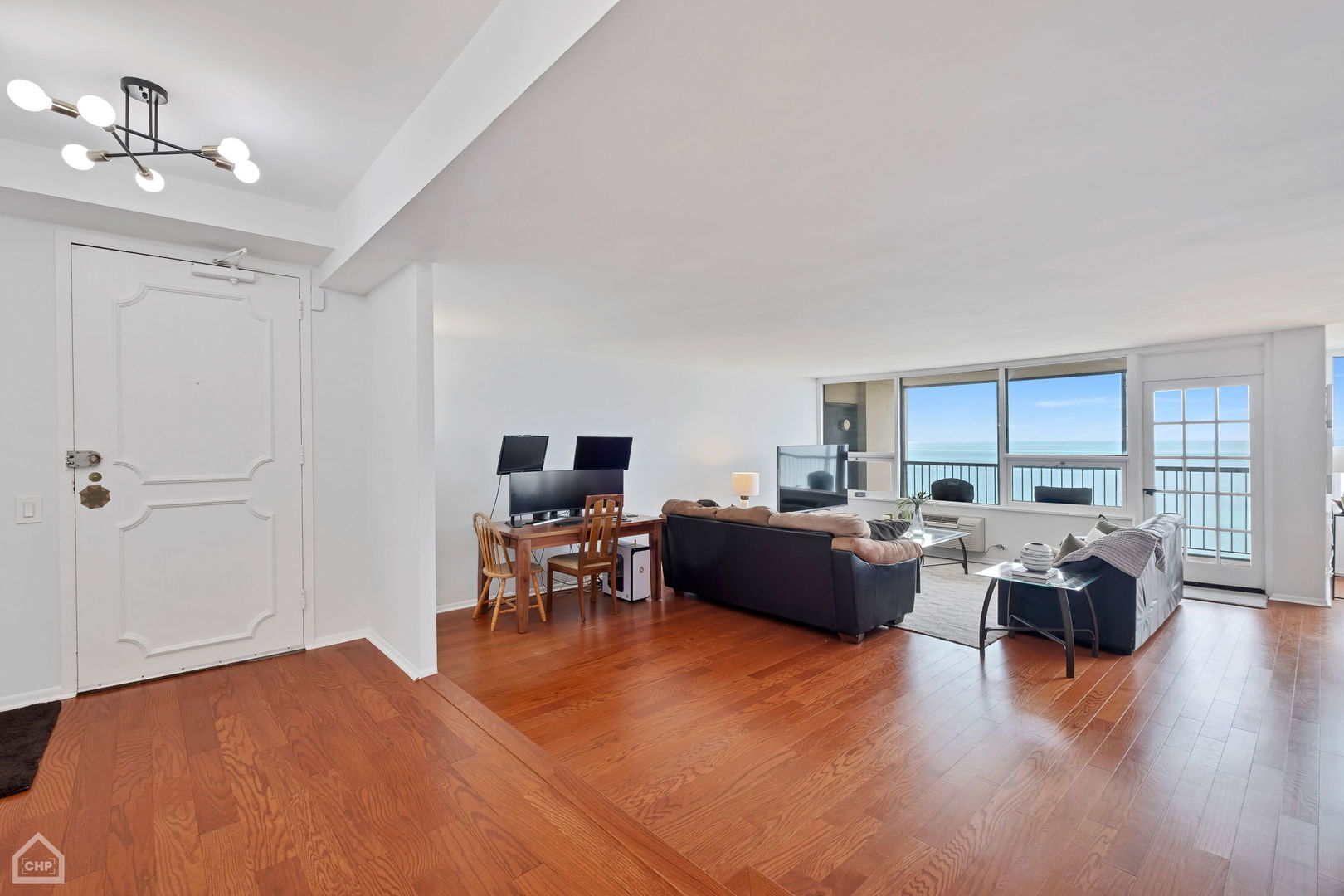 5733 North Sheridan Road, Unit 25C Chicago, IL 60660 - Photo 2 of 39 a living room with furniture and a flat screen tv