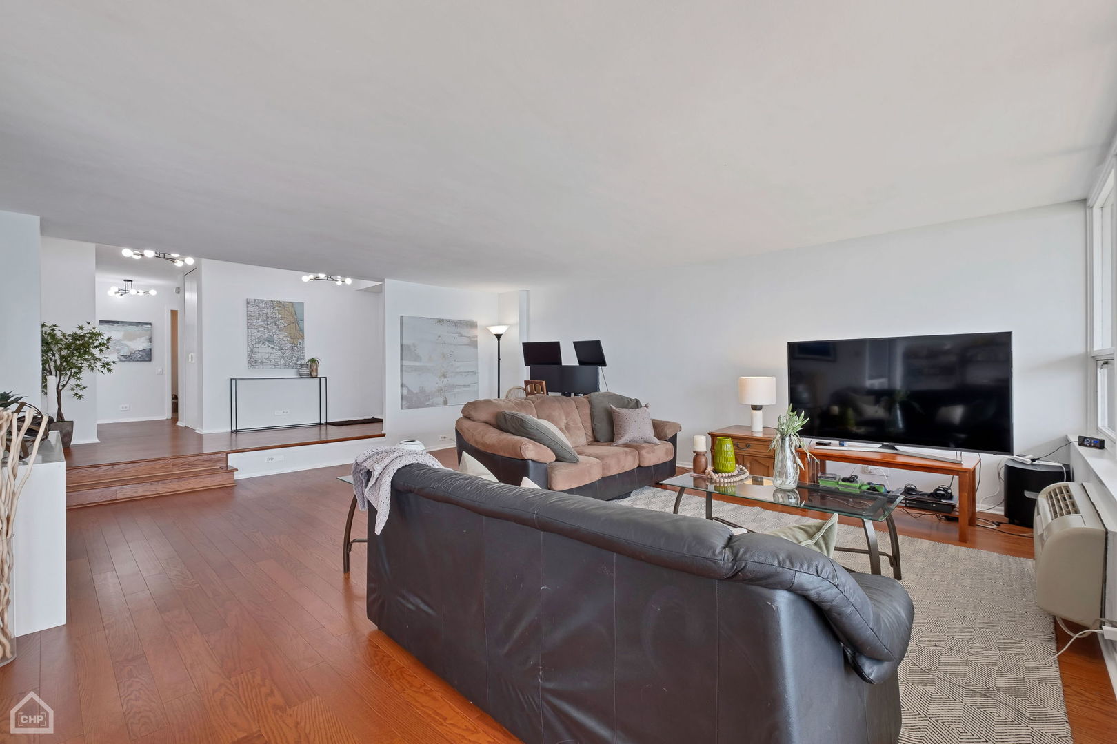 5733 North Sheridan Road, Unit 25C Chicago, IL 60660 - Photo 3 of 39 a living room with furniture and a flat screen tv