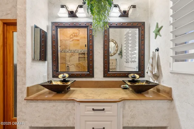 a bedroom with a bed a flat screen tv and a chandelier