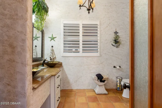 a bedroom with a bed a mirror on dresser and a flat screen tv