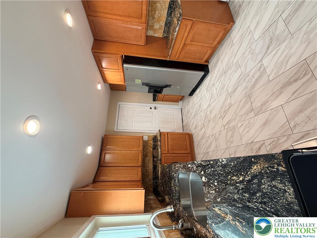 718 Ferry Street Easton, PA 18042 - Photo 8 of 37 A well-appointed kitchen features rich cabinetry, granite countertops, and modern flooring.