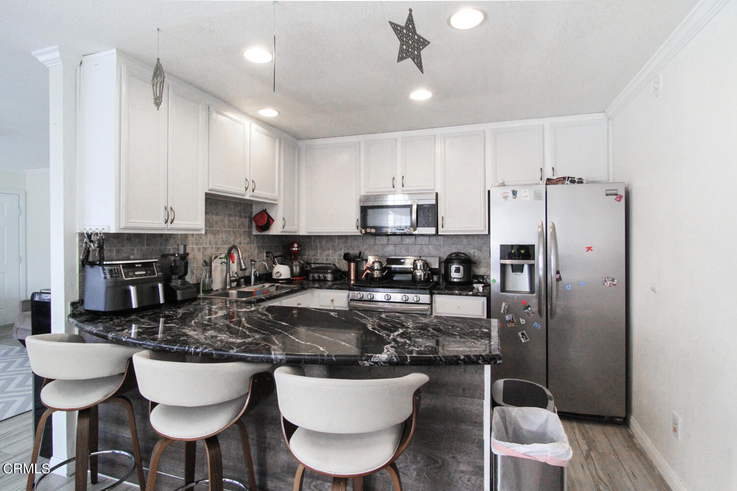 19230 Hamlin Street, Unit 1 Reseda, CA 91335 - Photo 7 of 17 a kitchen with stainless steel appliances granite countertop a sink a stove a refrigerator cabinets and chairs