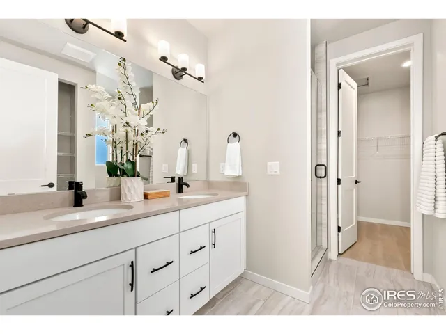 a spacious bathroom with a granite countertop sink a mirror and a shower