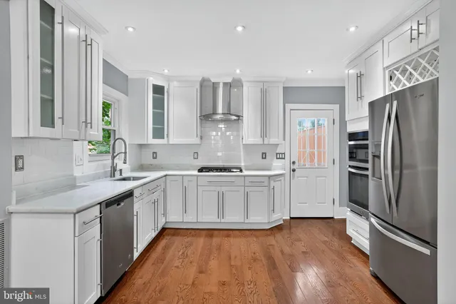 a large kitchen with stainless steel appliances a sink and refrigerator