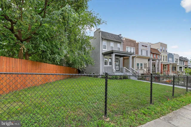 a backyard of a house with plants and wooden fence