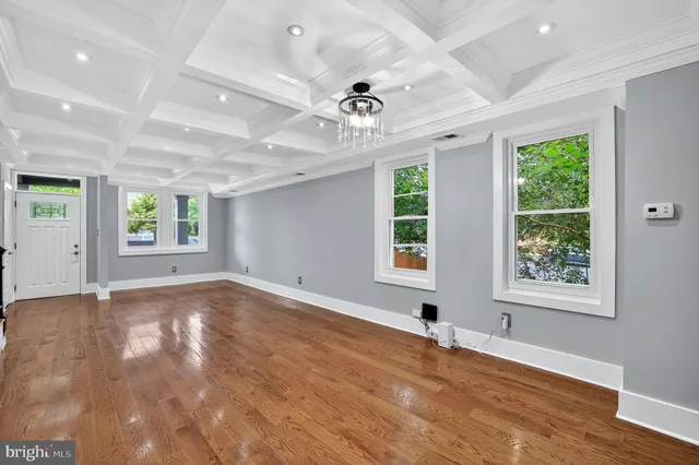 an empty room with windows and ceiling fan