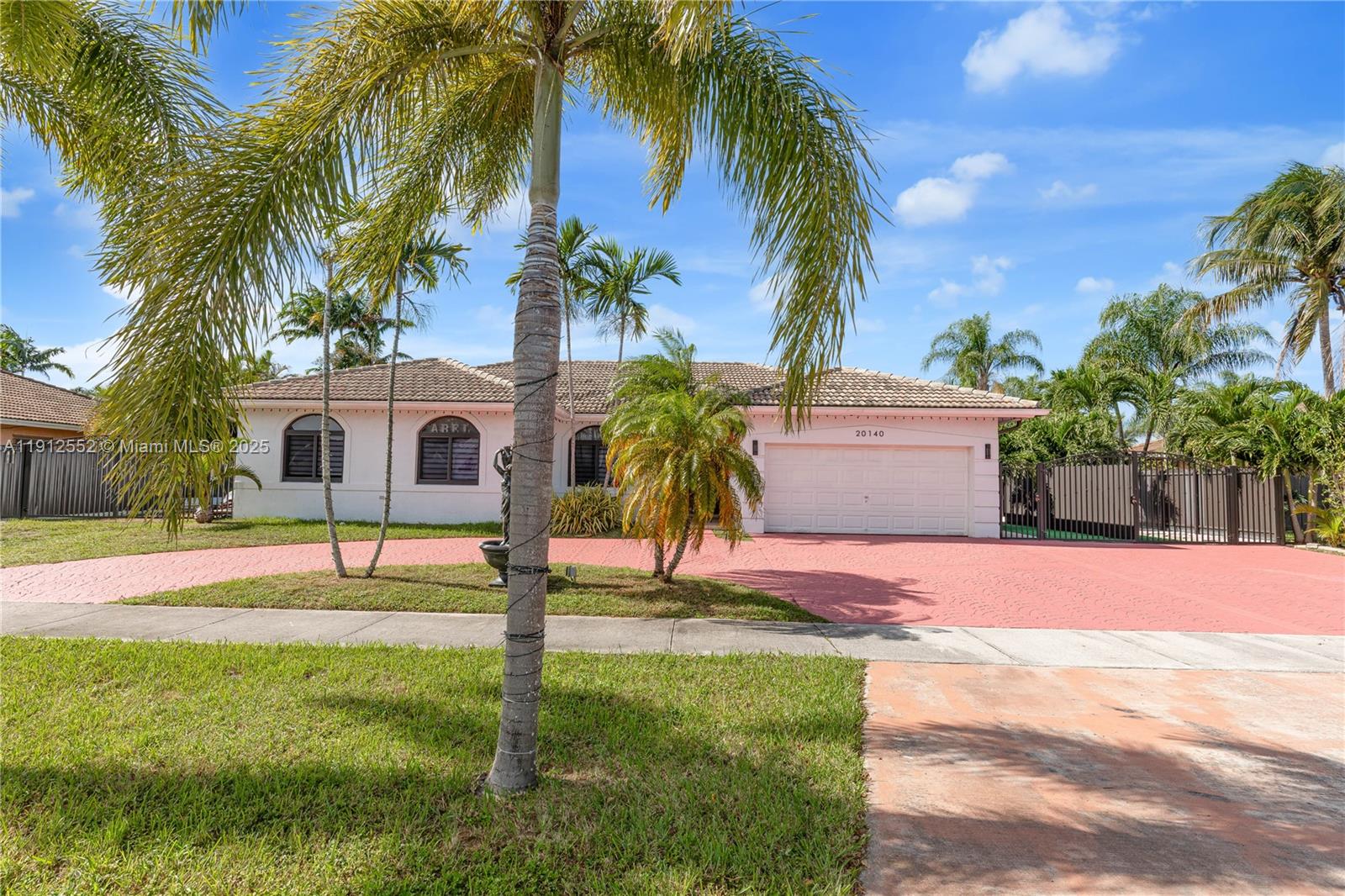 a palm tree sitting in front of a house with a yard