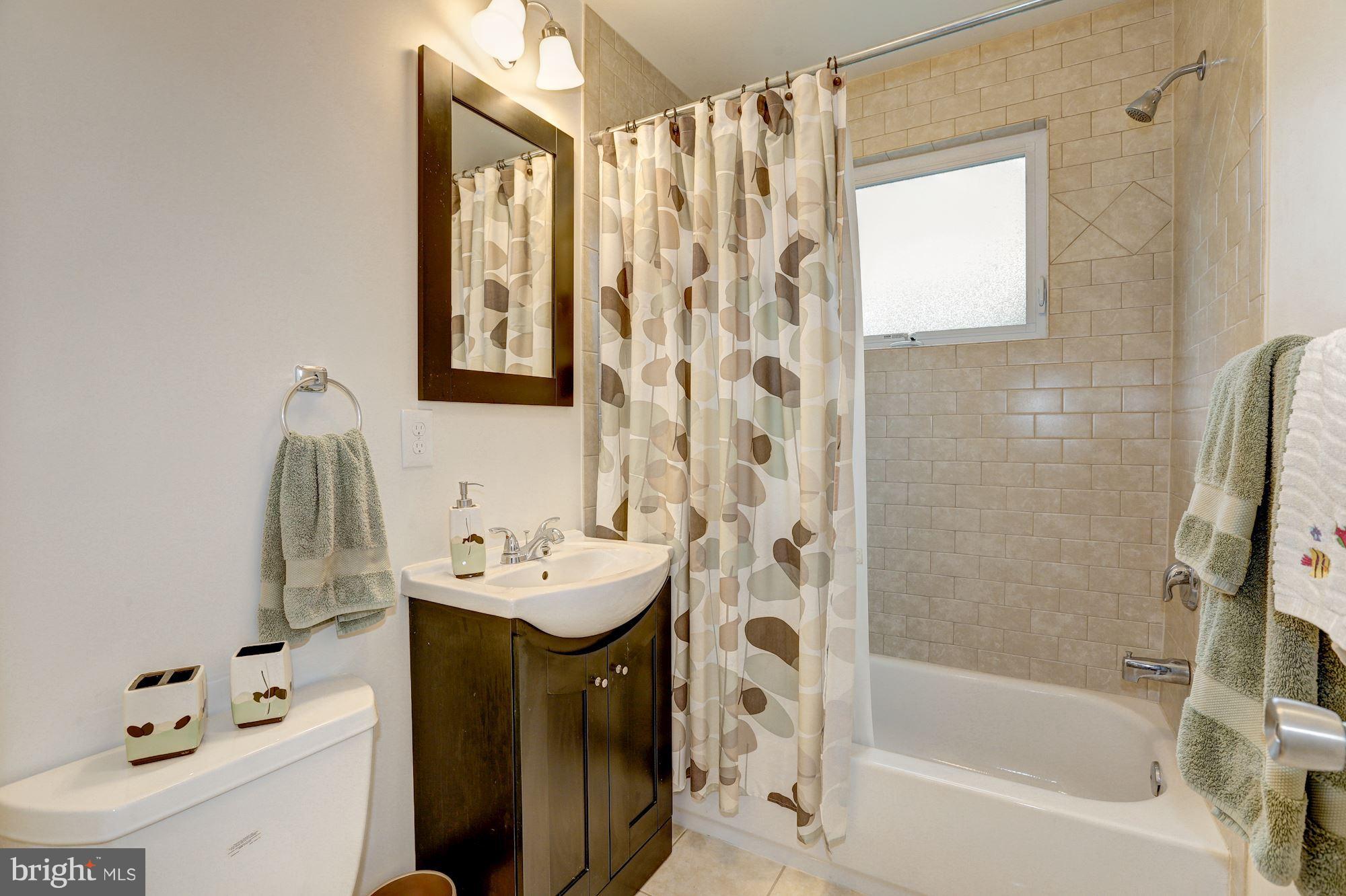 10409 Procter Street Silver Spring, MD 20901 - Photo 16 of 30 a bathroom with a sink a mirror and a bathtub
