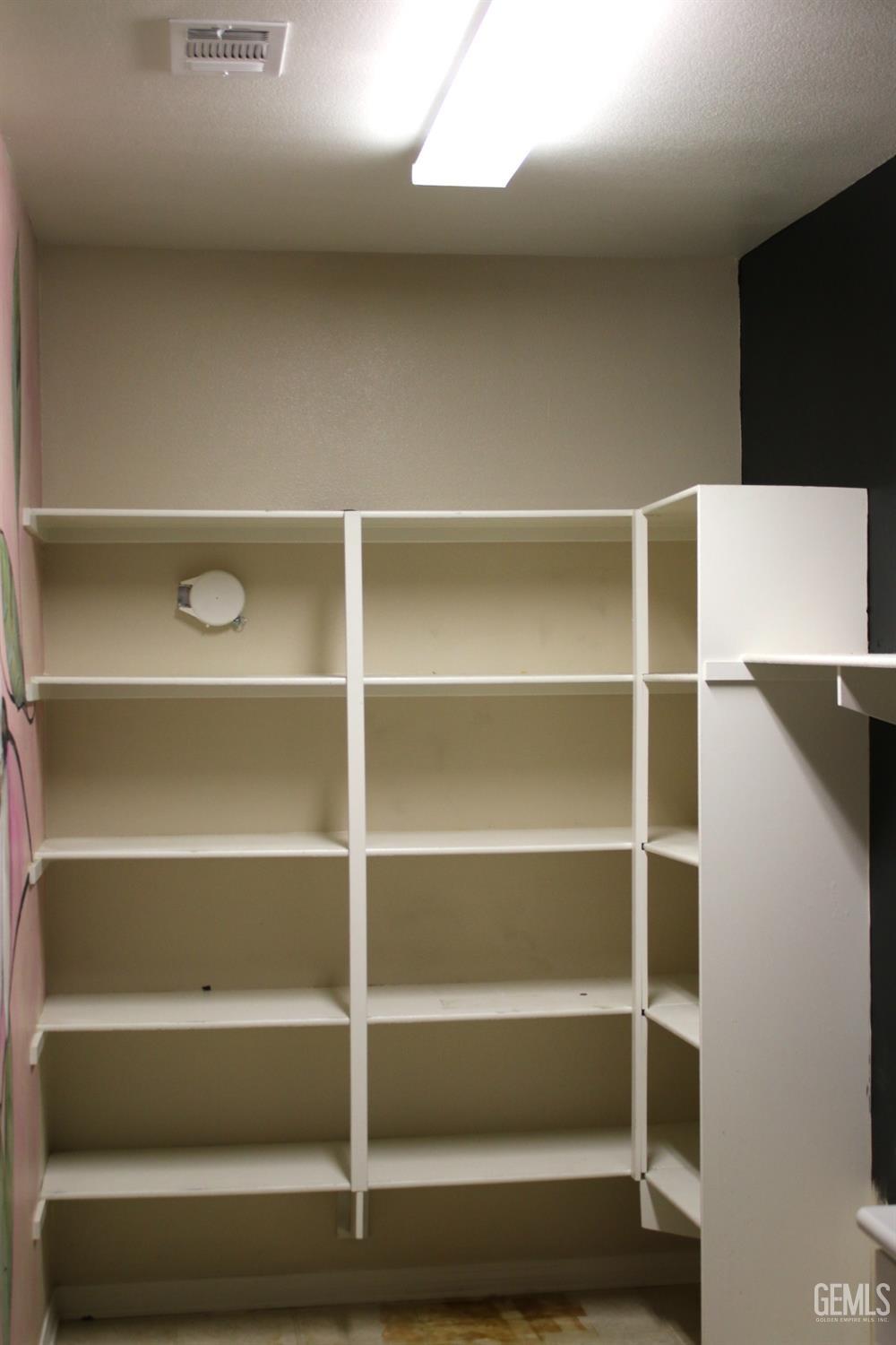 Undisclosed Address Bakersfield, CA 93313 - Photo 17 of 26 a view of walk in closet with empty racks