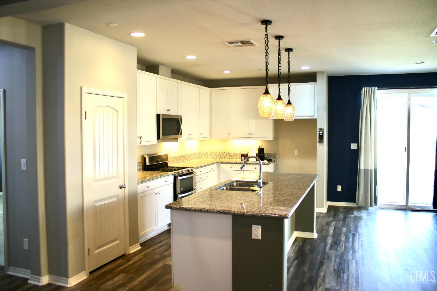 Undisclosed Address Bakersfield, CA 93313 - Photo 4 of 26 a kitchen with kitchen island granite countertop a sink appliances cabinets and a counter top space