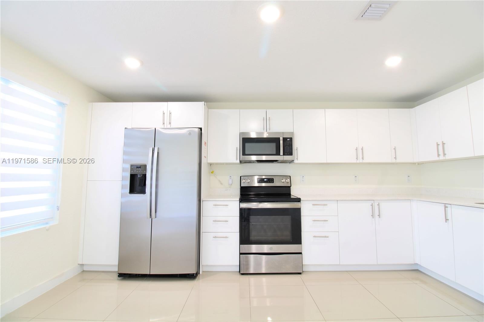 25875 Southwest 145th Avenue Homestead, FL 33032 - Photo 15 of 30 a kitchen with stainless steel appliances a refrigerator sink and microwave