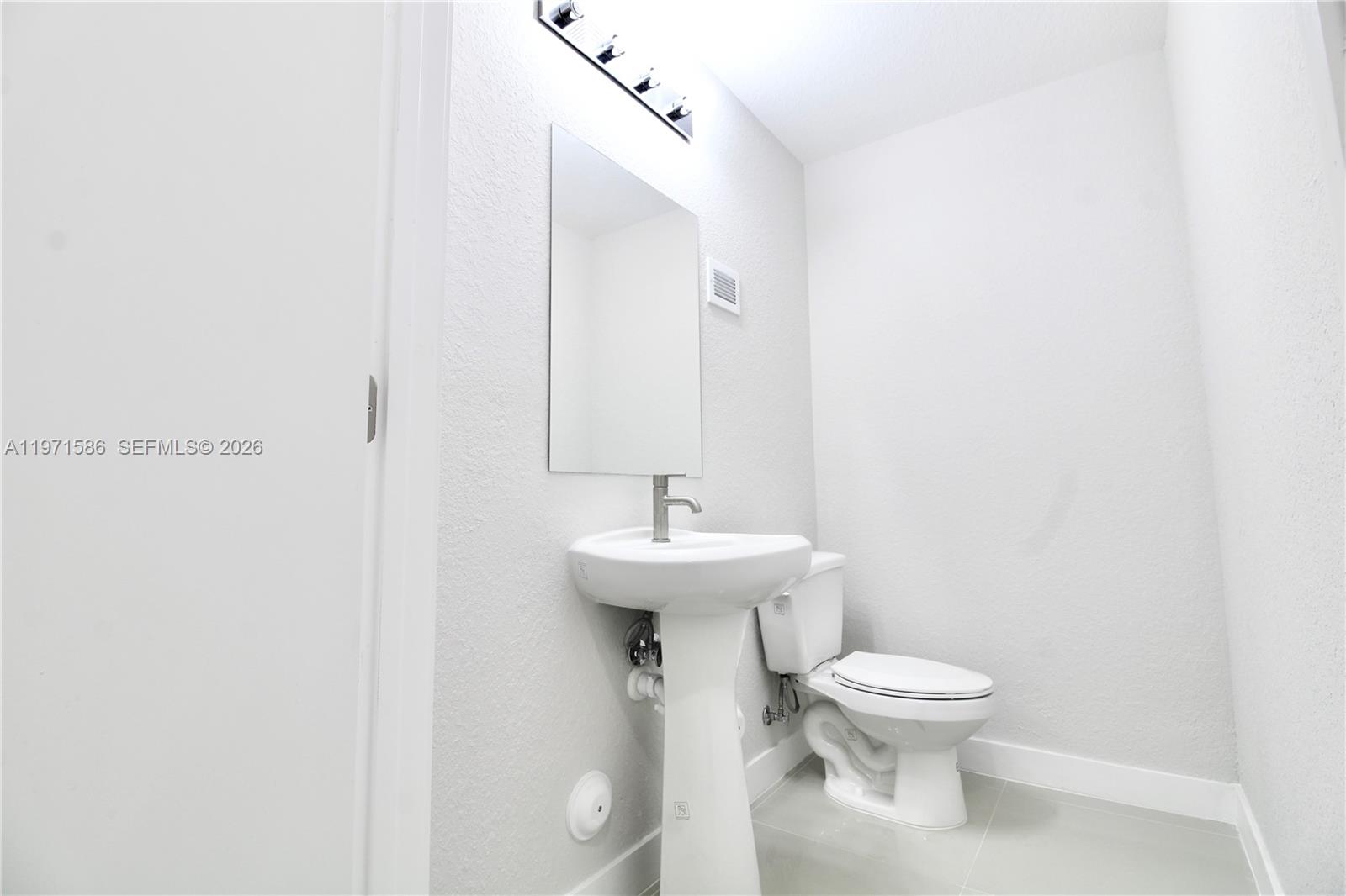 25875 Southwest 145th Avenue Homestead, FL 33032 - Photo 22 of 30 a bathroom with a sink a toilet and mirror