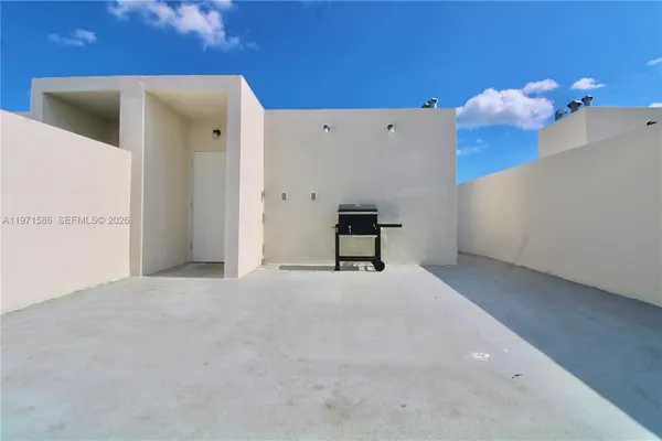 a view of a room with a white wall and a window