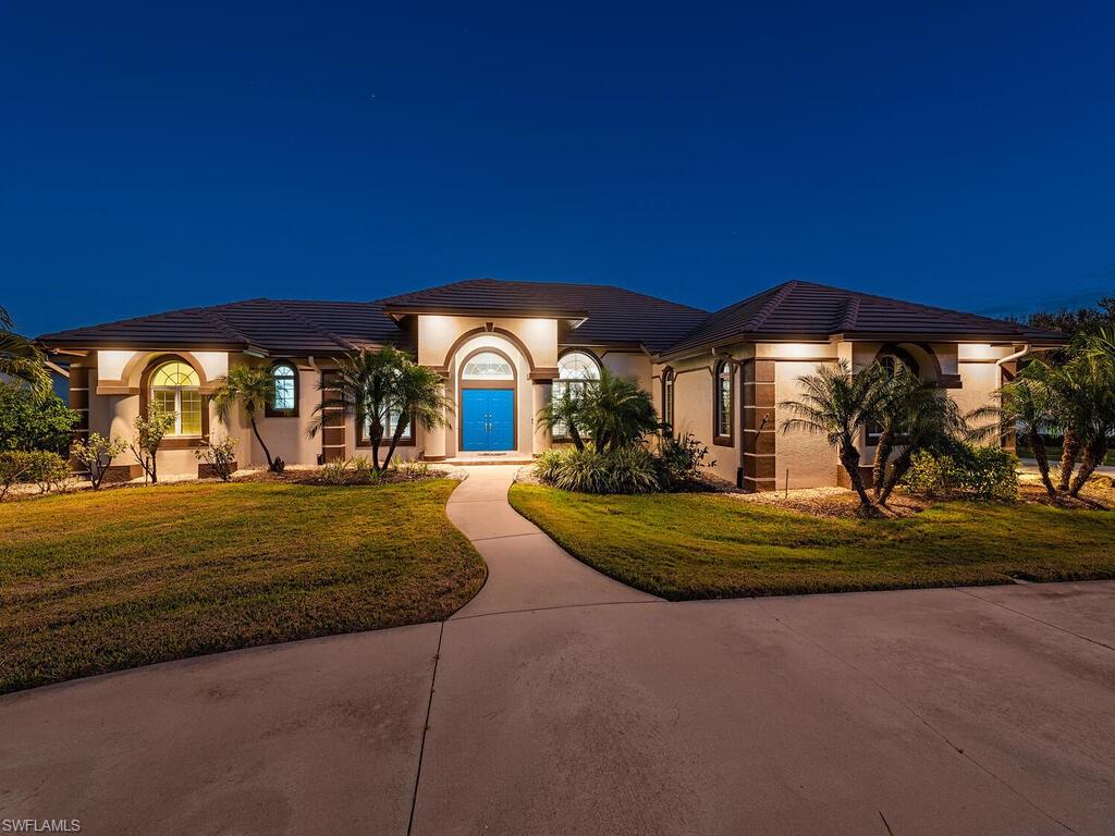 Mediterranean / spanish house featuring stucco siding, a lawn, and a tile roof
