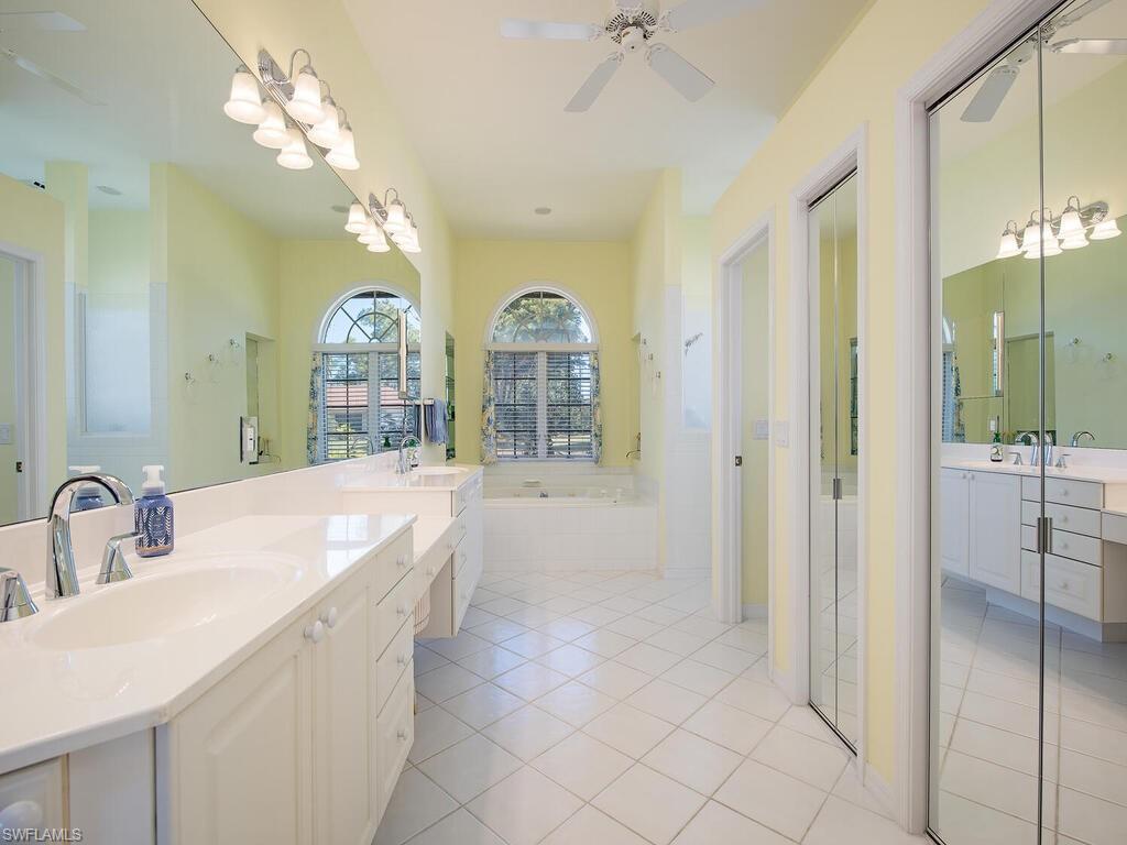 1832 Imperial Golf Course Boulevard Naples, FL 34110 - Photo 9 of 24 Full bathroom with double vanity, two vanities, a ceiling fan, a bath, and light tile patterned floors