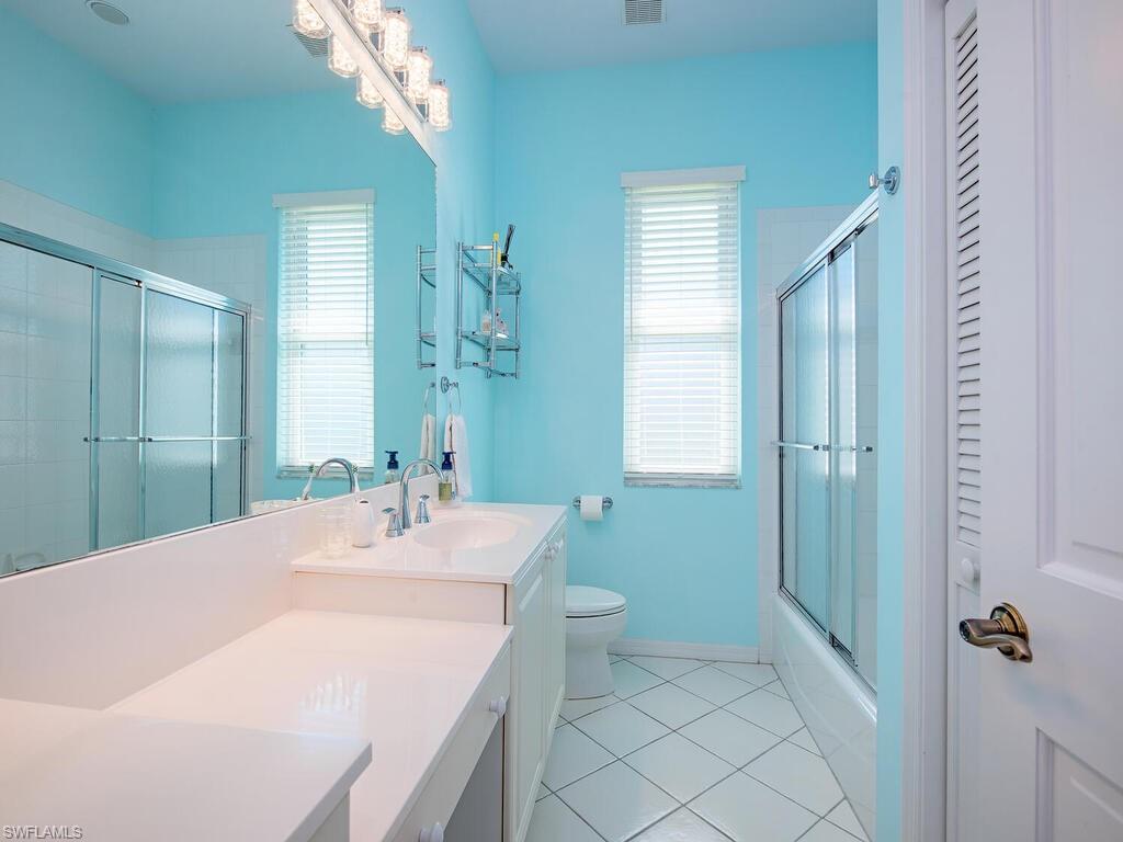 1832 Imperial Golf Course Boulevard Naples, FL 34110 - Photo 13 of 24 Full bathroom with vanity, light tile patterned flooring, and shower / bath combination with glass door