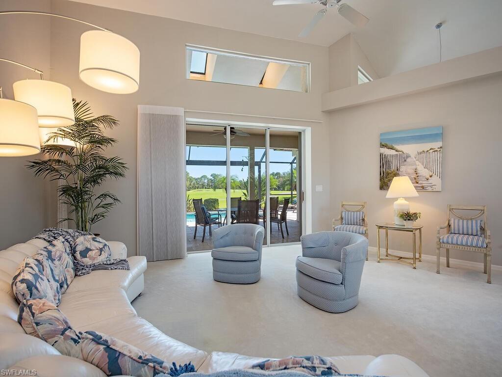 1832 Imperial Golf Course Boulevard Naples, FL 34110 - Photo 2 of 24 Carpeted living area featuring high vaulted ceiling and ceiling fan