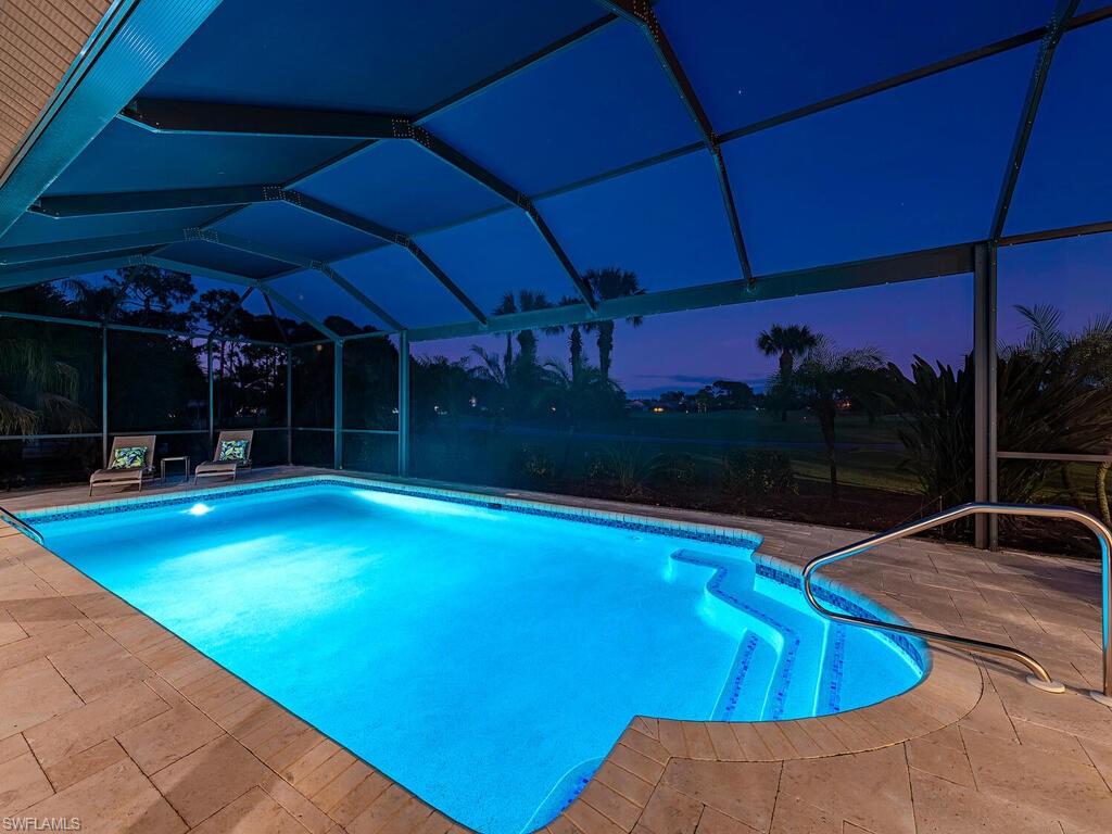 1832 Imperial Golf Course Boulevard Naples, FL 34110 - Photo 19 of 24 Swimming pool featuring glass enclosure, a sunroom, and a patio