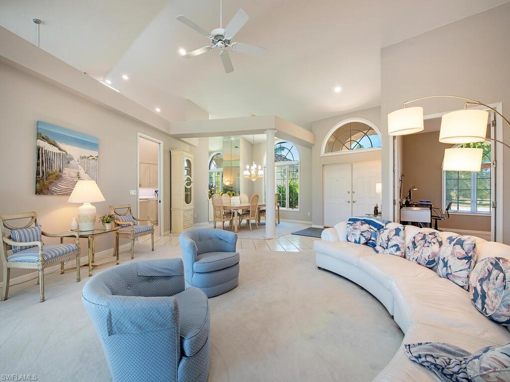 1832 Imperial Golf Course Boulevard Naples, FL 34110 - Photo 3 of 24 Living room featuring a towering ceiling, recessed lighting, light colored carpet, a ceiling fan, and a chandelier