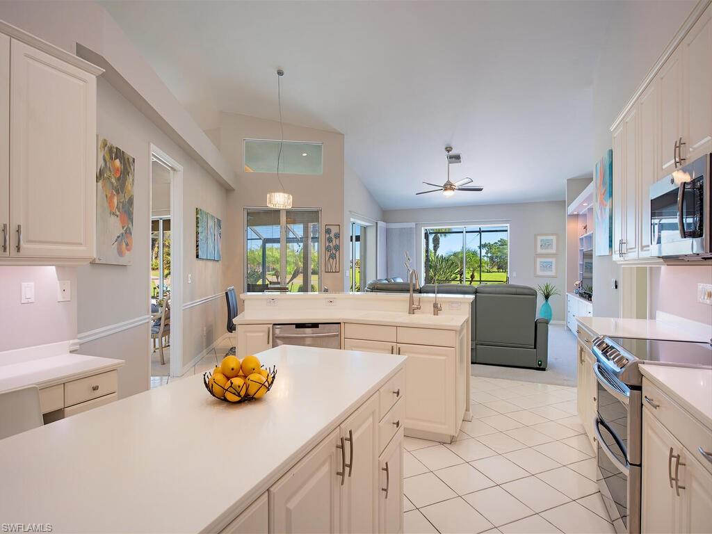 1832 Imperial Golf Course Boulevard Naples, FL 34110 - Photo 24 of 24 Kitchen with a center island, vaulted ceiling, appliances with stainless steel finishes, pendant lighting, and open floor plan