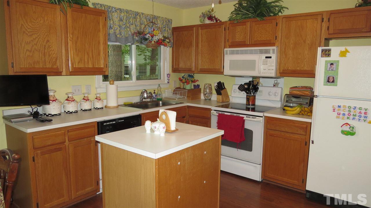 12125 Ranleigh Court Raleigh, NC 27613 - Photo 3 of 16 a kitchen with a sink a stove and cabinets
