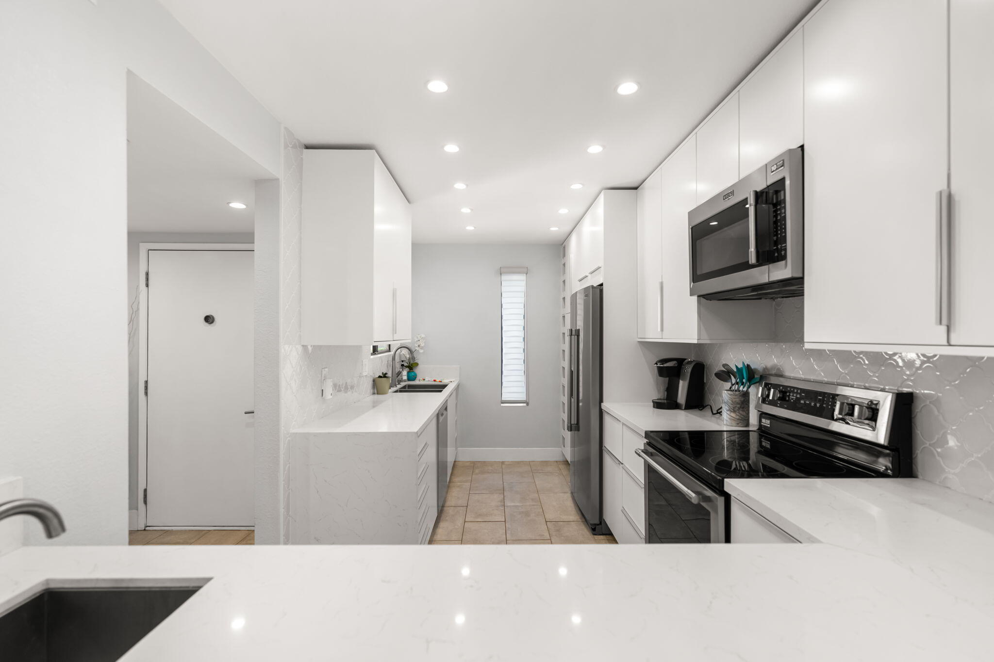 877 East Arenas Road Palm Springs, CA 92262 - Photo 12 of 43 a kitchen with stainless steel appliances a sink a stove top oven a refrigerator cabinets and a dining table