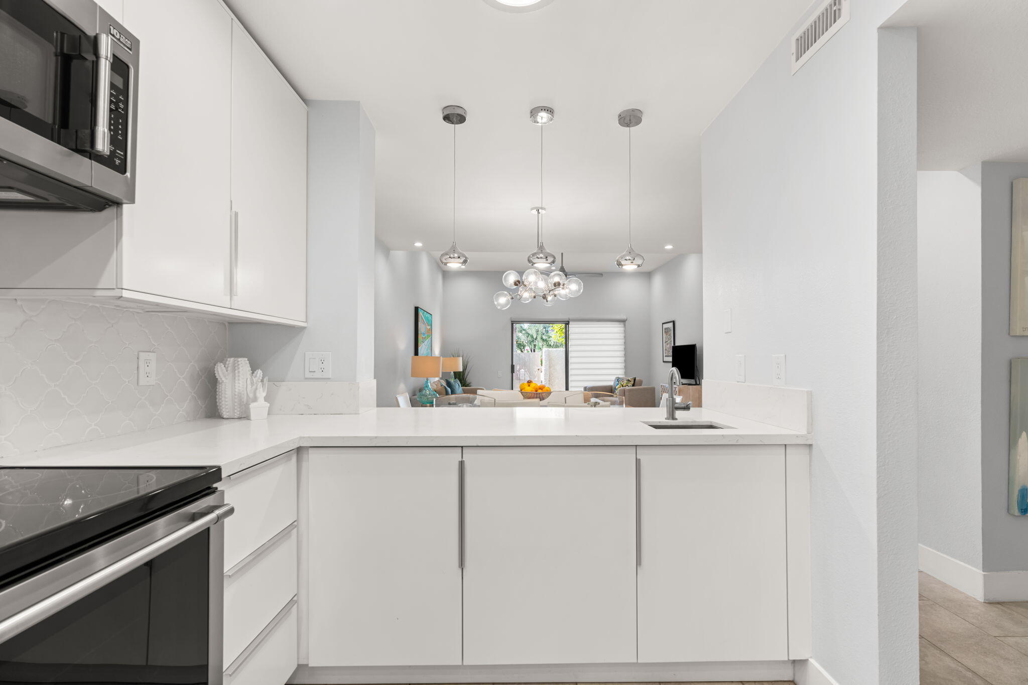 877 East Arenas Road Palm Springs, CA 92262 - Photo 17 of 43 a kitchen with kitchen island granite countertop a sink and white cabinets