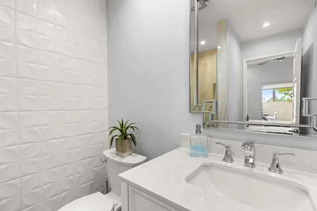 a bathroom with a toilet a sink a shower and mirror