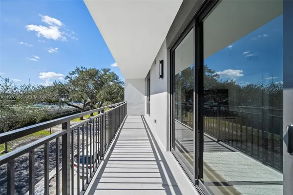 a view of a balcony with wooden floor and floor to ceiling window