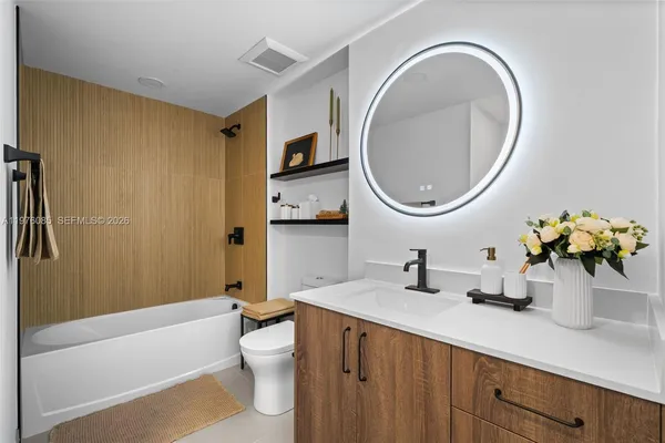 a bathroom with a sink a toilet and a mirror
