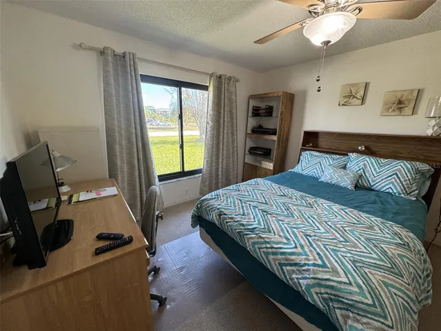 a bedroom with a bed and a flat tv screen on the dresser