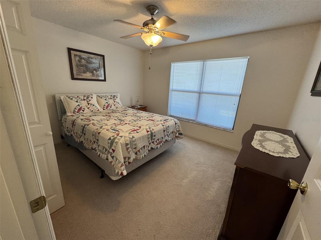 329 Genesis Pointe Drive, Unit 329 Lake Wales, FL 33859 - Photo 19 of 29 a bedroom with a bed and a lamp on the dresser