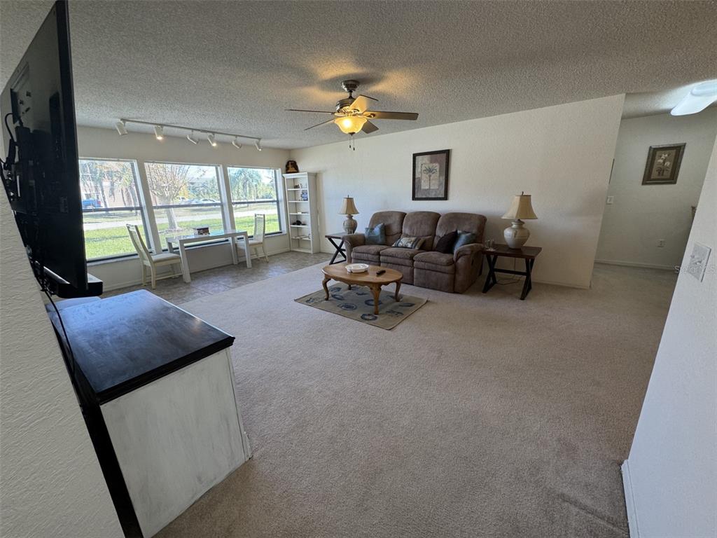 329 Genesis Pointe Drive, Unit 329 Lake Wales, FL 33859 - Photo 5 of 29 a living room with furniture and a flat screen tv