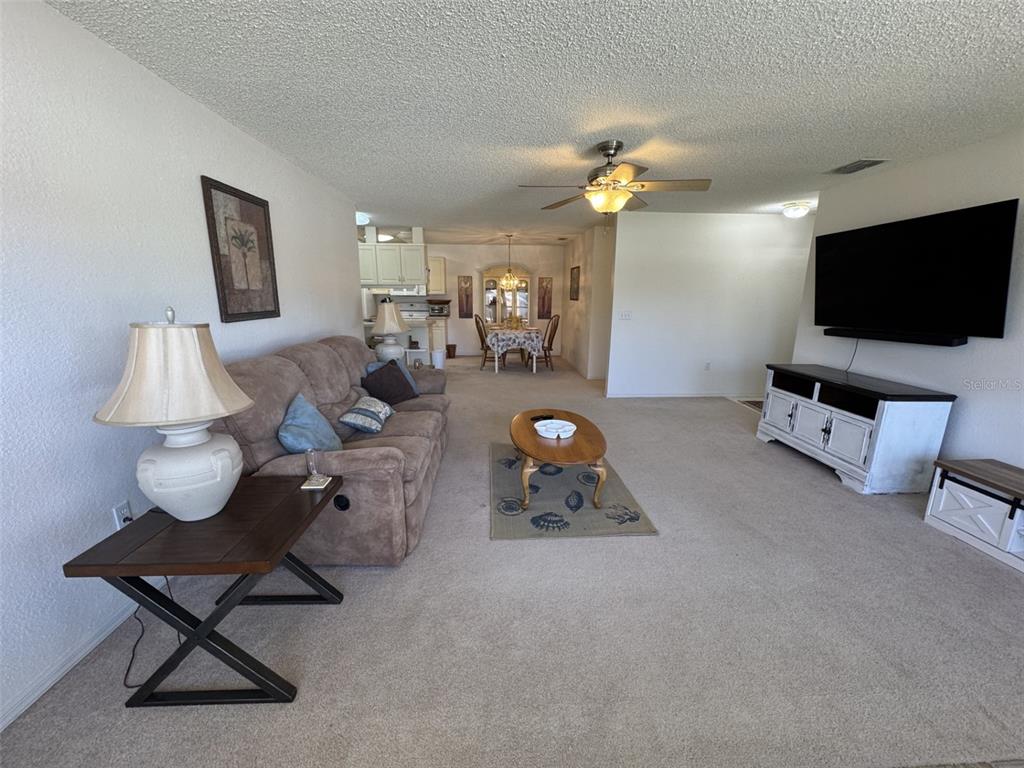 329 Genesis Pointe Drive, Unit 329 Lake Wales, FL 33859 - Photo 6 of 29 a living room with furniture and a flat screen tv