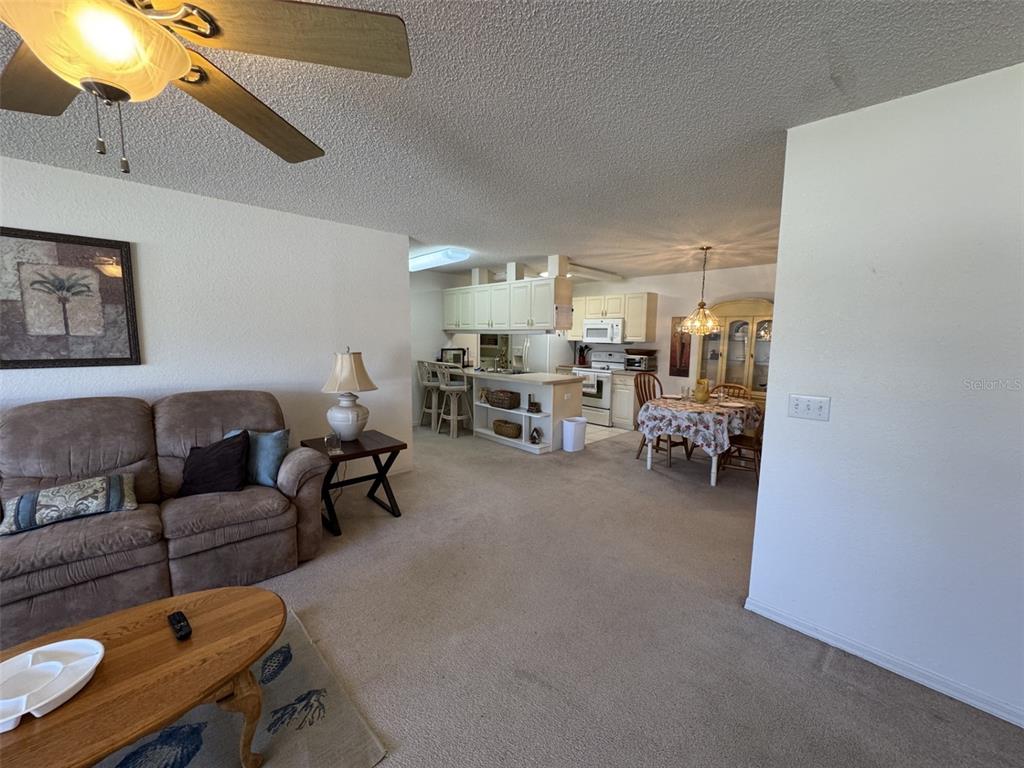 329 Genesis Pointe Drive, Unit 329 Lake Wales, FL 33859 - Photo 7 of 29 a living room with furniture and a chandelier