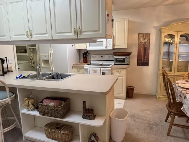 a kitchen with a white cabinets and chairs