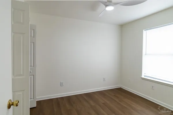 an empty room with a window and wooden floor