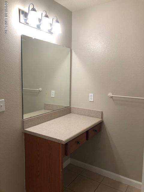 8550 Touchton Road, Unit 938 Jacksonville, FL 32216 - Photo 24 of 32 a bathroom with a sink and mirror