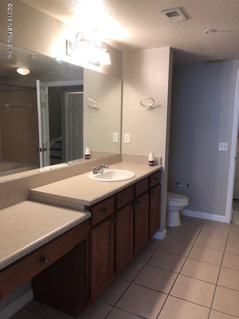 8550 Touchton Road, Unit 938 Jacksonville, FL 32216 - Photo 10 of 32 a bathroom with a sink a toilet and a large mirror